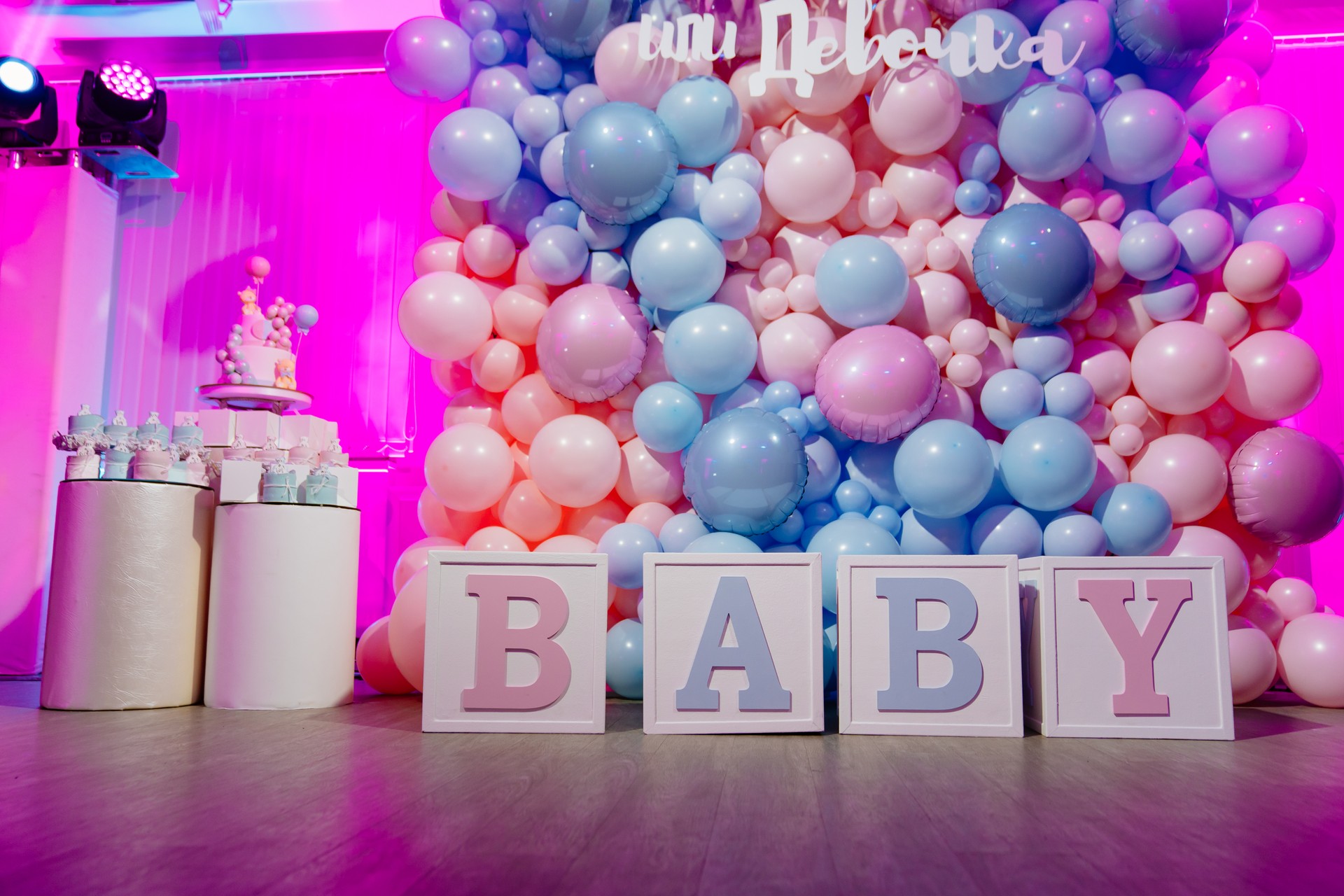 Photo zone for a gender party made of cubes and pink and blue balloons